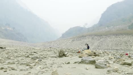 Guía-nepalí-tiene-un-descanso-en-la-piedra.-Circuito-de-Manaslu-trek.