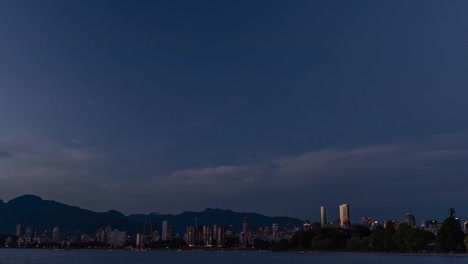 high-rise-buildings-of-modern-seaside-city,-yachts-and-ships,-from-the-ocean-side-against-the-background-of-mountains