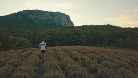 hombre-joven-camina-ocasional-en-un-campo-de-la-montaña-en-la-noche-durante-la-temporada-de-verano