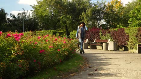 Mujer-pasa-por-el-parque-del-jardín-de-flores-4K