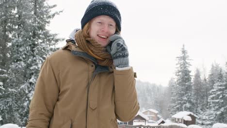 Young-Guy-Having-Phone-Talk-during-Walk-at-Winter-Day