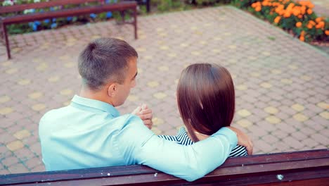 Romantisch-zu-zweit-sitzen-auf-der-Bank-im-Park-im-Sommer