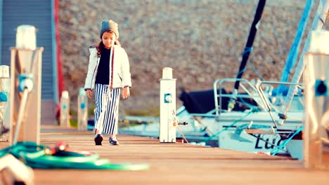 Mädchen-Spaziergänge-entlang-der-Marina-für-Boote-und-Boote