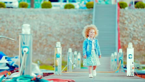 Girl-child-strolls-along-the-marina-for-boats-and-boats