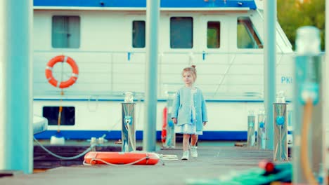 Small-child-strolls-along-the-marina-and-boats