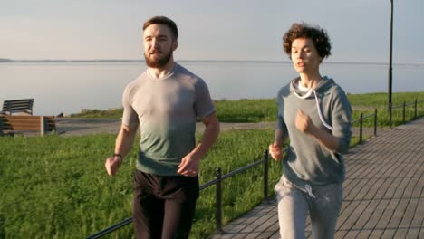 Sporty-Man-and-Woman-Running-Outdoors-at-Sunny-Day