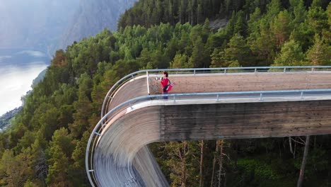 Tourist-enjoying-fjord-view-on-Stegastein-viewpoint-Norway