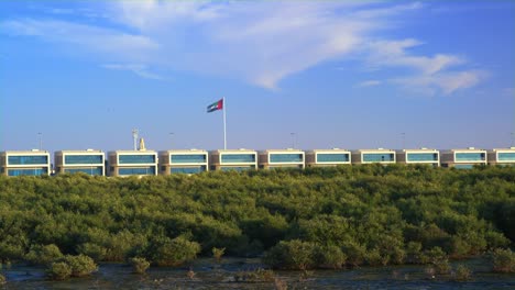 Die-Flagge-von-Dubai-auf-ein-Gebäude-mit-einem-Skyline-Hintergrund.