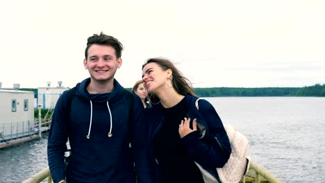 A-group-of-teenagers-are-walking-along-the-bridge-of-the-river