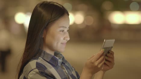 Young-Asian-woman-using-tablet-in-the-city-streets