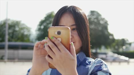 Beautiful-young-woman-talking-to-her-friends-with-portible-smart-phone