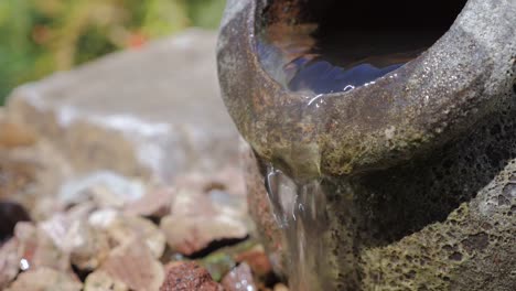 Fuente-de-agua-al-aire-libre-en-la-forma-de-una-urna-de-piedra-con-el-agua-que-sale