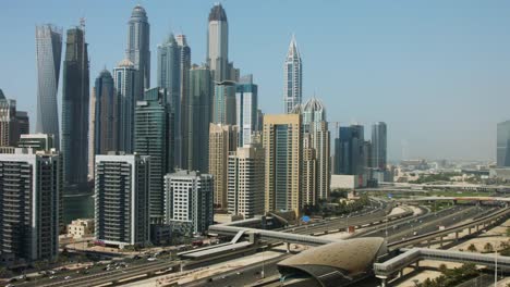 Pan-shot-of-towers-en-una-ciudad,-Dubai,-Emiratos-Árabes-Unidos