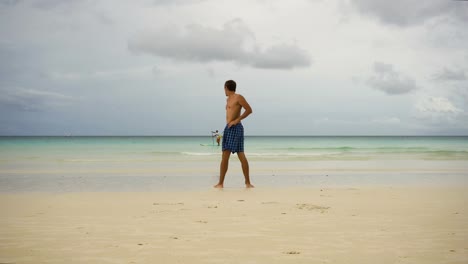 Hombre-haciendo-ejercicios-matutinos-en-la-playa