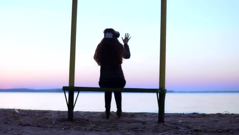 Atractiva-mujer-blanca-está-utilizando-gafas-de-realidad-virtual-por-el-lago-al-atardecer