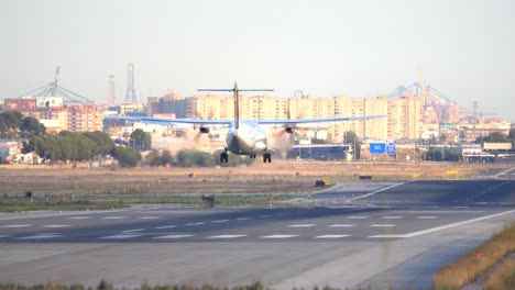 propeller-plane-landing-at-airport-runway,-rear-view