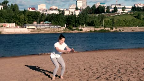 Frau-Sport-die-Übungen-an-den-Ufern-des-Flusses-in-der-Stadt.-Springen-aus-sitzender-Position.