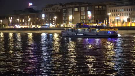 Nachtverkehr-von-Sportbooten-auf-einem-Fluss,-Stadt