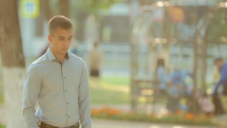 Portrait-of-a-young-man-waiting-for-someone-waiting-in-the-summer-or-in-the-spring-season-in-the-park