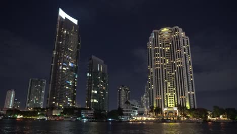 Bürogebäude-der-Wirtschaft-dreht-sich-nachts-in-einer-Metropole.-nächtliche-Stadt,-Blick-vom-Fluss.-Urban-style