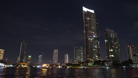 corporate-buildings-on-the-river-bank-in-the-metropolis.-night-time,-light-from-the-office-windows