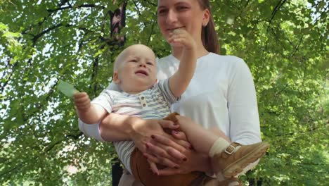 Mutter-mit-neugierigen-Baby-spazieren-im-Park