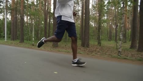 Black-Man-Jogging-along-Road-in-Forest