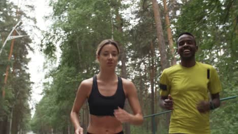 Cheerful-Black-Man-and-Woman-Jogging-in-Forest