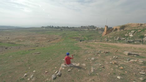 Child-looking-at-ruins-of-ancient-city-Hierapolis-in-Pamukkale,-Turkey