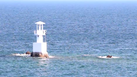 Leuchtturm-im-Meer,-mit-blauem-Himmel