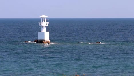 Leuchtturm-im-Meer,-mit-blauem-Himmel