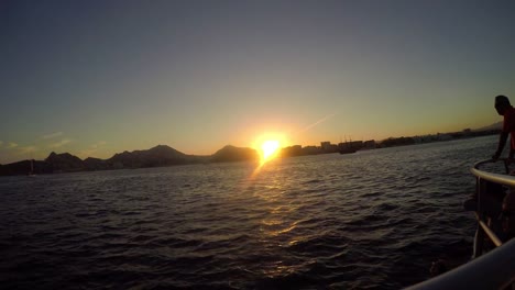 Vista-de-la-ciudad-en-la-costa-al-anochecer,-de-un-barco-en-el-mar