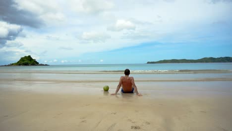 Mann-sitzt-am-Strand