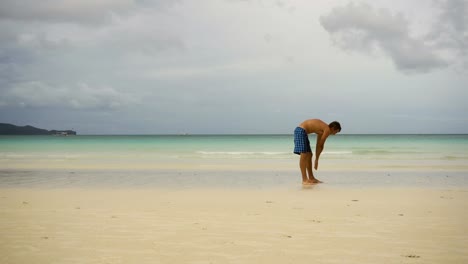 Hombre-haciendo-ejercicios-matutinos-en-la-playa