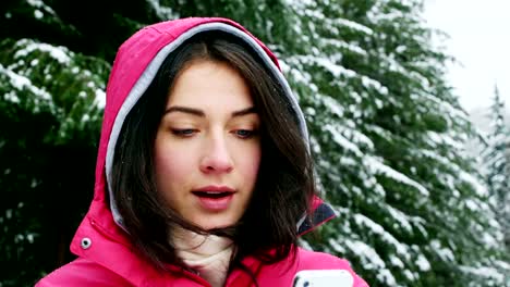 Smiling-woman-in-warm-clothing-using-mobile-phone