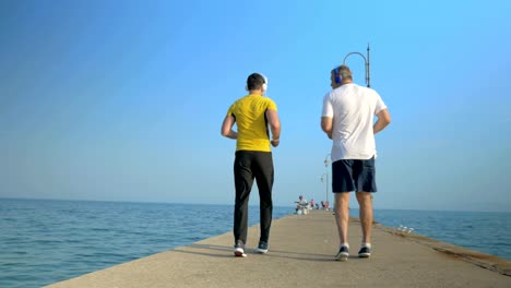 Men-exercising-by-walking-backward-along-the-pier