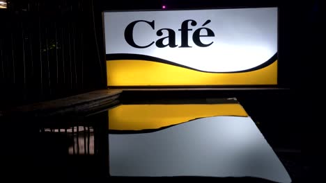 Beleuchtete-Café-Banner-in-der-Nacht