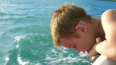 Kind-Reisen-mit-dem-Boot-und-versuchen,-Wasser-zu-berühren