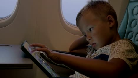 Niño-utilizando-la-pantalla-táctil-durante-el-vuelo