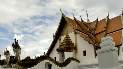 Time-Lapse-of-White-fluffy-clouds-in-the-blue-sky-and-Buddhist-temple-of-Wat-Phumin-in-Nan,-Thailand-background.