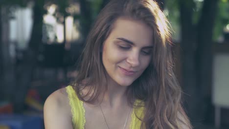 beautiful-girl-in-the-Park-sitting-at-a-table-with-a-smartphone