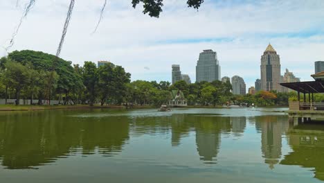 Estilo-urbano,-árboles-con-un-lago-en-el-parque-con-vistas-al-distrito-de-negocios-de-la-gran-ciudad.-edificios-corporativos-con-oficinas-y-empleados