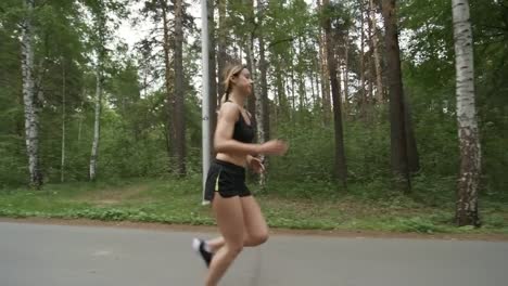 Deportiva-mujer-a-lo-largo-de-camino-forestal