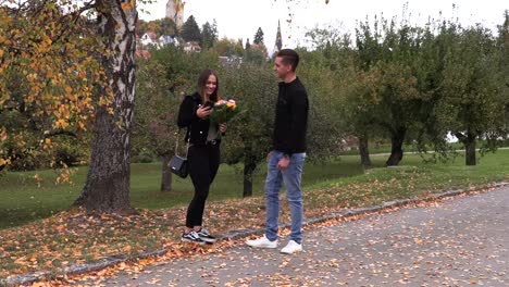 Young-brunette-girl-is-waiting-for-a-guy-with-flowers-on-a-date