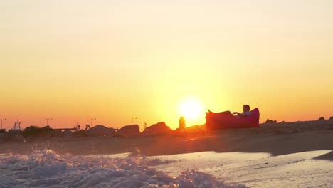 Sonnenuntergang-Szene-des-Mannes-in-aufblasbaren-Liege-am-Meer-entspannen