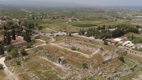 Vista-aérea-del-campo-de-la-arqueología-cerca-de-un-pueblo,-Grecia.