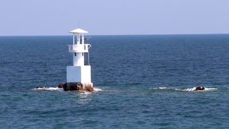 Leuchtturm-im-Meer,-mit-blauem-Himmel