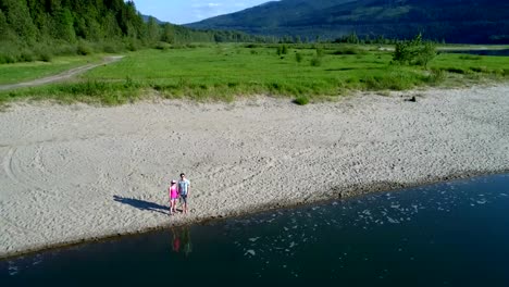 Couple-standing-together-on-lakeshore-4k