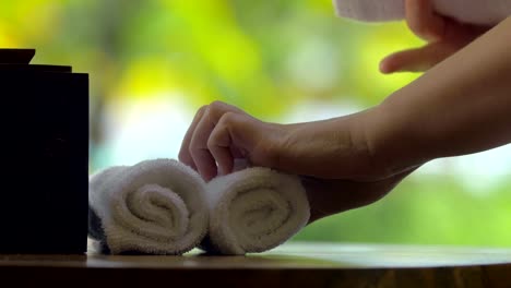 Platzieren-von-frischen-Handtüchern-mit-Blumen-auf-dem-Tisch-im-spa