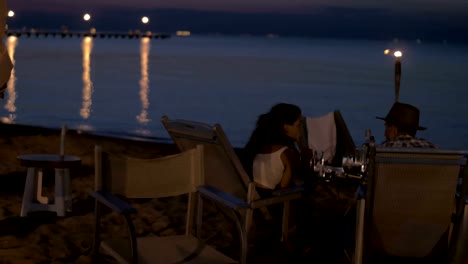 Vista-de-la-joven-pareja-feliz-teniendo-a-cena-romántica-en-la-playa,-Grecia